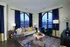Cozy and stylish living room featuring arched windows, plush seating with vibrant cushions, and elegant decor in soothing tones.