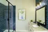 Elegant bathroom with modern blue-tile shower, stylish vanity, and framed artwork adds a touch of luxury.