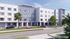 Modern four-story apartment building with sleek architecture, surrounded by lush greenery and convenient parking.