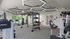 Modern fitness center with state-of-the-art exercise equipment, stylish geometric lighting, and vibrant outdoor views.