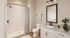 Modern bathroom with elegant fixtures, granite countertop, and a spacious shower, offering a serene and stylish retreat.