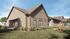 Charming modern home with elegant wooden exterior, surrounded by lush greenery, showcasing a welcoming outdoor space on a sunny day.