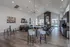 Chic modern lounge area with high ceilings, elegant chandeliers, and a stylish open-concept design featuring cozy seating, vibrant artwork, and a sleek kitchen space.