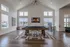 Modern recreation room featuring a stylish pool table, elegant lighting, and large windows for natural light.