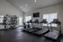 Modern fitness center featuring state-of-the-art treadmills, weight machine, and expansive windows for natural light.