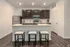 Modern kitchen with dark wood cabinets, stainless steel appliances, and a stylish breakfast bar with seating.
