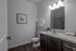 Elegant bathroom with modern fixtures, dark wood cabinetry, and bright lighting, offering a serene and stylish retreat.