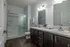 Modern bathroom with elegant dark wood cabinetry, dual sinks, and a sleek glass-enclosed shower.