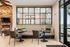 Charming seating area with elegant table and chairs, featuring a cozy stone fireplace and modern decor with large windows.