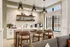 Modern kitchen with elegant open shelving, stylish pendant lights, and a cozy breakfast bar with plush seating.