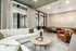 Elegant modern living area with a cozy white sectional sofa, stylish armchairs, and a chic round coffee table. The room features large windows, soft lighting, and inviting decor, perfect for relaxation or entertaining.