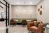 Chic seating area with plush green booth, modern leather chairs, and artistic wall decor in a contemporary apartment lounge.