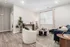 Inviting living room with modern decor, featuring a cozy white armchair, plush blue sofa, and elegant wood flooring.
