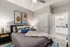 Inviting bedroom with modern decor, featuring a cozy bed, stylish artwork, and a glimpse into an elegant en-suite bathroom.