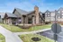Charming modern apartment complex with stone accents and lush landscaping under a clear blue sky, featuring a welcoming entrance and inviting pathways.