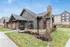 Charming apartment exterior with rustic stone and wood details, surrounded by lush greenery in a serene neighborhood.