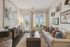 Bright and inviting living room featuring a plush sofa, chic decor, and a large window with garden views.