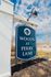 Inviting sign for Woods at Perry Lane residence, set against a picturesque blue sky and serene suburban backdrop.