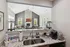 Elegant open-concept living area seen from the kitchen, featuring a cozy stone fireplace, ample natural light, and modern decor.