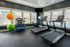 Modern fitness room with large windows, featuring state-of-the-art treadmills, exercise bike, and a variety of colorful stability balls for dynamic workouts.