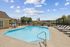 Inviting outdoor pool area with lounge chairs and a tranquil garden setting, perfect for relaxation and leisure.