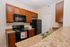 Charming and functional kitchen with rich wooden cabinets, modern appliances, and stylish countertops.