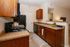 Charming kitchen with warm wooden cabinets, sleek countertops, and modern appliances, seamlessly connected to the living area.