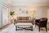 Chic living room with a cozy brown sofa, elegant decor, plush area rug, and a stylish leather armchair.