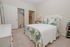 Charming bedroom with cozy bed, elegant patterned bedding, and ample closet space, creating a serene and inviting atmosphere.