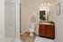 Elegant bathroom with modern shower and stylish vanity, complemented by warm wooden cabinets and soft lighting.