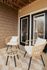 Charming outdoor patio featuring cozy wicker chairs and a stylish round table, perfect for relaxing afternoons.