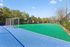 Vibrant outdoor sports court with dual soccer nets surrounded by lush greenery and blue skies, perfect for active living.