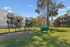 Charming apartment complex with spacious wooden balconies, surrounded by lush greenery and pet-friendly amenities.