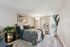 Elegant bedroom with a cozy bed, stylish decor, and abundant natural light from large windows, creating a relaxing atmosphere.