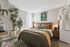 Modern bedroom retreat with stylish decor, lush indoor plants, and a cozy, inviting aesthetic.