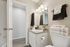 Contemporary bathroom featuring elegant vanity, chic lighting, and fresh towels, perfect for modern living.