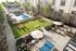 Luxurious apartment courtyard with a sparkling pool, lush green lawn, cozy seating areas, and vibrant flower gardens.