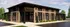 Elegant exterior of The Reserve at Mill Run, showcasing modern architecture with brick design, large windows, and lush landscaping under a clear blue sky.