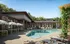Luxurious apartment complex featuring a beautiful outdoor pool area surrounded by greenery and stylish seating, perfect for relaxation and leisure.