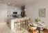 Elegant kitchen and dining area featuring modern pendant lighting, sleek cabinetry, and a stylish breakfast bar with chic seating.