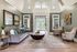 Inviting living room with high ceilings, elegant decor, and ample natural light flowing through large windows.