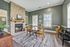 Charming dining room with a rustic stone fireplace, elegant round table, and stylish decor, perfect for cozy gatherings.