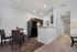 Chic kitchen and dining area with modern appliances, cozy lighting, and elegant dark wood flooring, offering a stylish and welcoming living space.