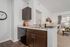 Modern apartment kitchen with sleek countertops, stainless steel dishwasher, and cozy living area featuring large windows and bright natural light.