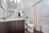 Modern bathroom with elegant granite countertop, stylish dark wood cabinetry, and inviting neutral tones, offering a luxurious living experience.