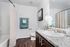 Contemporary bathroom with elegant granite countertops, stylish vanity, and modern fixtures, complemented by a chic shower curtain and plush towels on dark wood flooring.