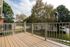 Charming balcony with elegant railing, surrounded by lush greenery and a serene neighborhood view.