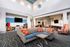 Modern community lounge with vibrant decor, cozy seating, and a sleek entertainment area, showcasing high ceilings and contemporary lighting.