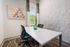 Contemporary office space with geometric artwork, textured wall, and natural light filtering through the window.
