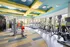 Vibrant fitness center with modern exercise equipment, bright lighting, and large windows offering scenic outdoor views.